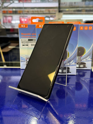 Black smartphone on a stand with K3 packaging in the background