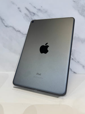 A gray Apple iPad shown from the back, resting on a clear stand against a white marble-patterned background.