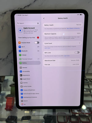 A black tablet showing the iPad Settings app screen with Battery Health details, photographed on a countertop with a marble-patterned surface behind it.