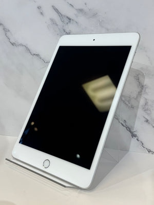 A white Apple iPad tablet with a black screen, displayed at an angle on a clear acrylic stand against a white marble-patterned background.