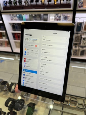 Tablet displaying settings menu in a store setting with watches on display