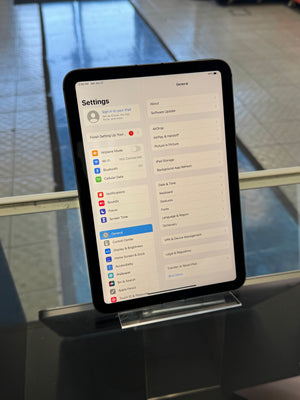 Digital tablet displaying a settings menu on a metallic surface