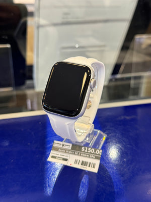 Smartwatch with a white band on a blue surface, possibly in a store setting.