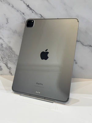 A silver Apple iPad Pro standing upright on a small display stand against a white marble-patterned background.
