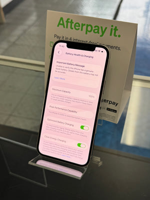 Smartphone displaying battery health screen with 'Afterpay it' advertisement in the background.