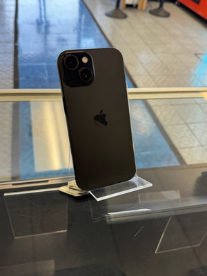 Black smartphone on a clear stand with a blurred indoor background