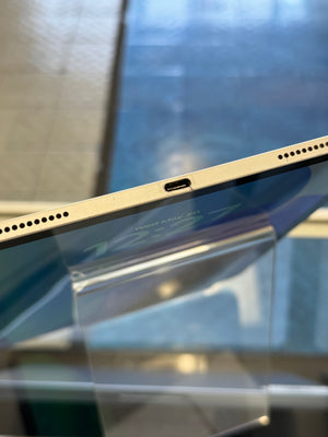 Close-up of a tablet's side profile with charging port on a reflective surface