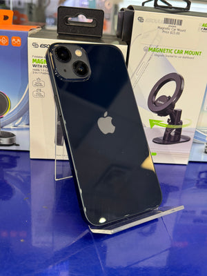 Black smartphone with Apple logo on a blue surface, surrounded by magnetic car mount packaging.
