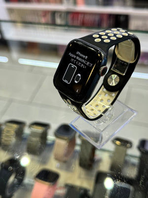 Smartwatch with a decorative black case and gold accents on a reflective surface.