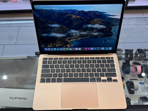 Open laptop displaying a mountainous landscape on a glass surface
