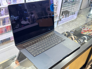 Laptop on display in a store with shelves and products in the background