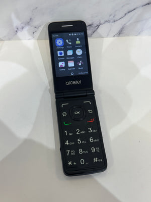 A black Alcatel flip phone with a large screen and physical numeric keypad, shown open on a white marble-patterned surface.