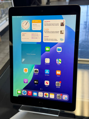 Tablet displaying a home screen with app icons on a stand.