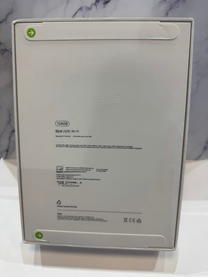 The back of a white iPad product box showing product specifications, barcodes, and regulatory marks against a marble-patterned background.