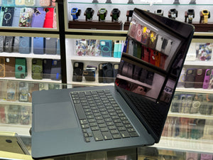 Laptop with a reflective screen displaying multiple images in a store setting.