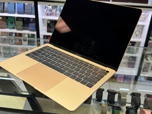Gold laptop on a glass surface with a store shelf in the background