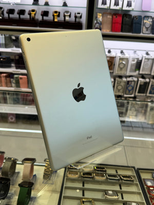 Back view of a silver Apple product with a logo on a reflective surface