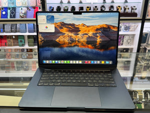 Laptop displaying a scenic wallpaper in a store setting with products in the background