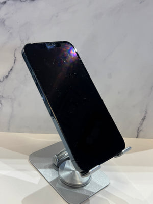 A black smartphone displayed at an angle on a silver metal stand, set against a white marble-patterned background.