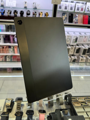 Black tablet on a stand in a store setting with various products in the background
