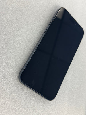 A black smartphone with a glossy screen, shown from an angled top-down view on a light gray textured surface.