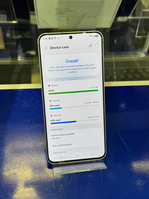 Smartphone displaying device care app on a blue surface