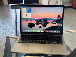 Laptop on a stand with a scenic wallpaper on the screen