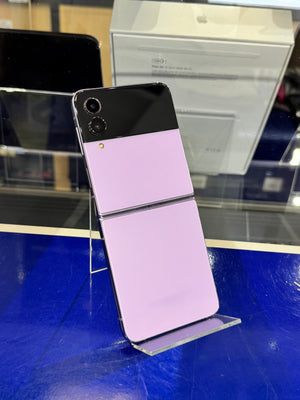 Smartphone with black and purple design on a stand in a store setting