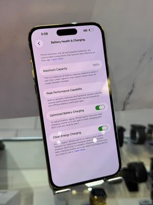 A close-up of a smartphone screen showing the Battery Health & Charging settings page, photographed against a softly blurred indoor background.