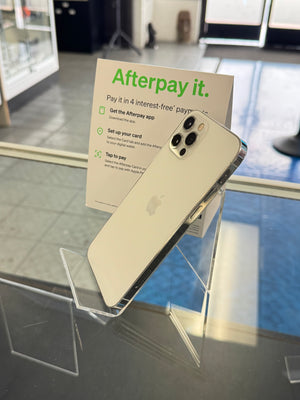 Gold smartphone on a stand with 'Afterpay it.' sign in the background