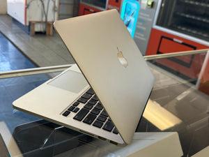 Silver laptop with Apple logo on a glass surface in an indoor setting
