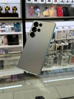 A silver colored Samsung smartphone with a three camera system displayed in a store setting