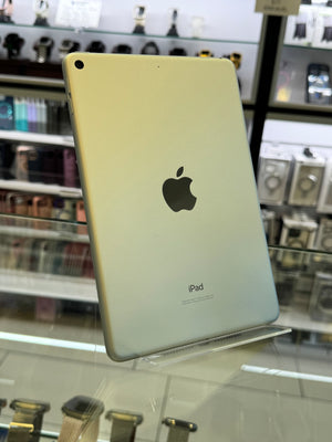 Back view of an iPad with Apple logo on a glass surface in a store setting.