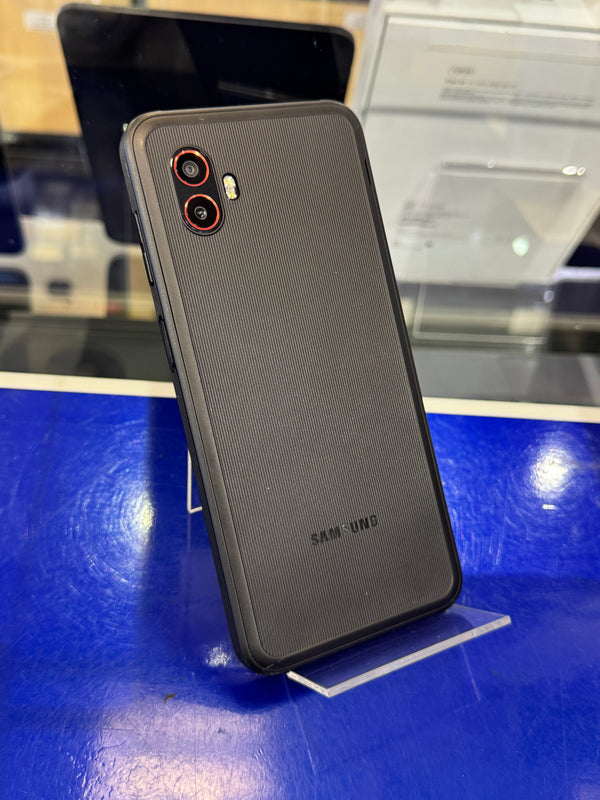 Black smartphone with a textured back on a blue surface