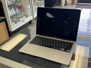 Laptop on a glass surface with a store interior in the background