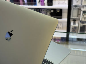 Close-up of a laptop with an Apple logo in a store setting