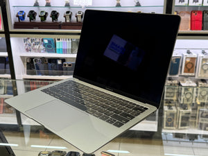 Laptop on a glass surface with a store shelf in the background