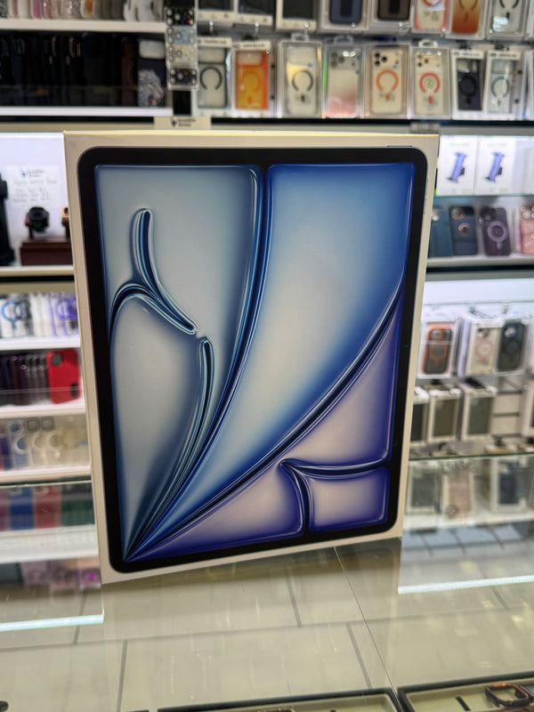 A square abstract wall art print with a blue and white fluid design, displayed on a glass counter inside a retail store.