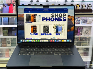 Laptop displaying a phone store website with phone cases in the background