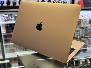 Apple laptop on a reflective surface with a blurred store background