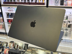 Gray laptop with Apple logo on a display stand in a store