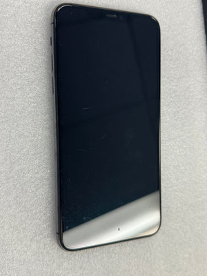 A black smartphone with a glossy screen, shown from the back, resting on a textured light gray surface.