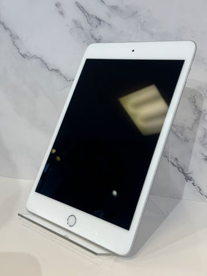 A white Apple iPad tablet with a black screen, resting on a clear acrylic stand against a white marble-patterned background.