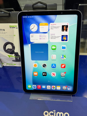 Tablet with a home screen display on a blue surface with a car holder in the background.