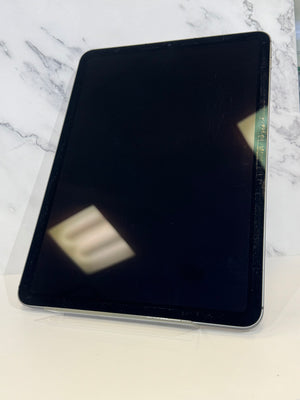 A black tablet with a glossy screen, resting on a clear plastic display stand against a white marble-patterned background.