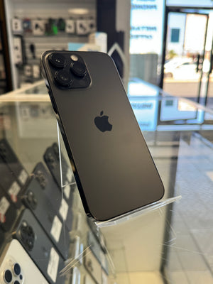 A black Apple iPhone 13 Pro shown from the back, resting on a clear display stand inside a retail store.