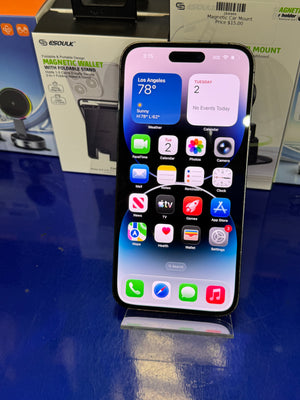Smartphone with app icons displayed on a reflective surface with packaging in the background
