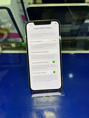 An iPhone smartphone shown from the side with its screen on, displaying settings pages, placed against a blue surface.
