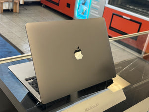 MacBook Air on a stand with an Apple logo in a store setting