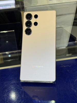 Samsung smartphone with silver back panel on a reflective surface